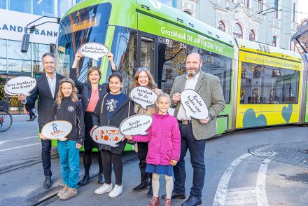 Kinder und Vertreter:innen der Stadt Graz vor einer Straßenbahn