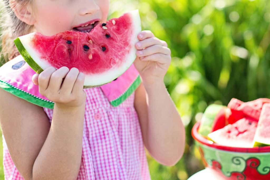 Mädchen isst Melonenspalte