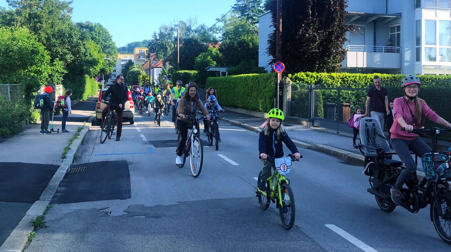 eine Gruppe Kinder und Erwachsener, die auf einer Straße mit dem Rad fährt