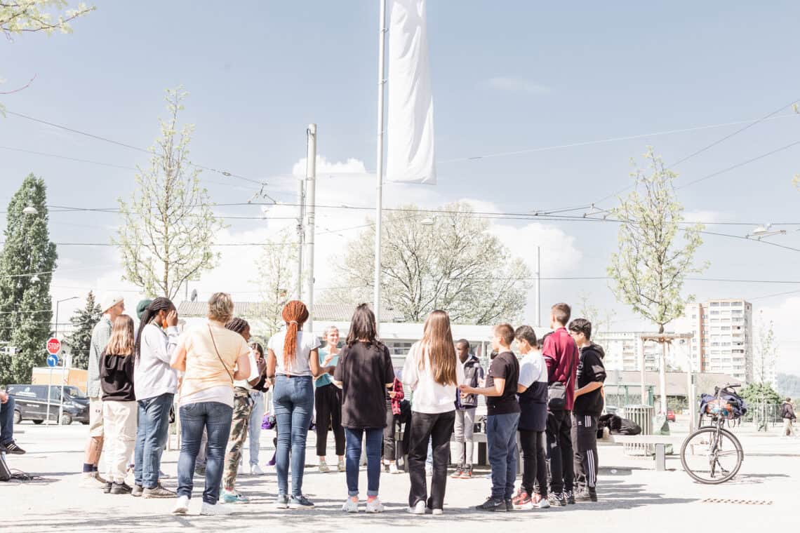 Schüler*innen am Bertha-von-Suttner-Platz in Graz, die im Kreis stehen und sich an den Händen halten